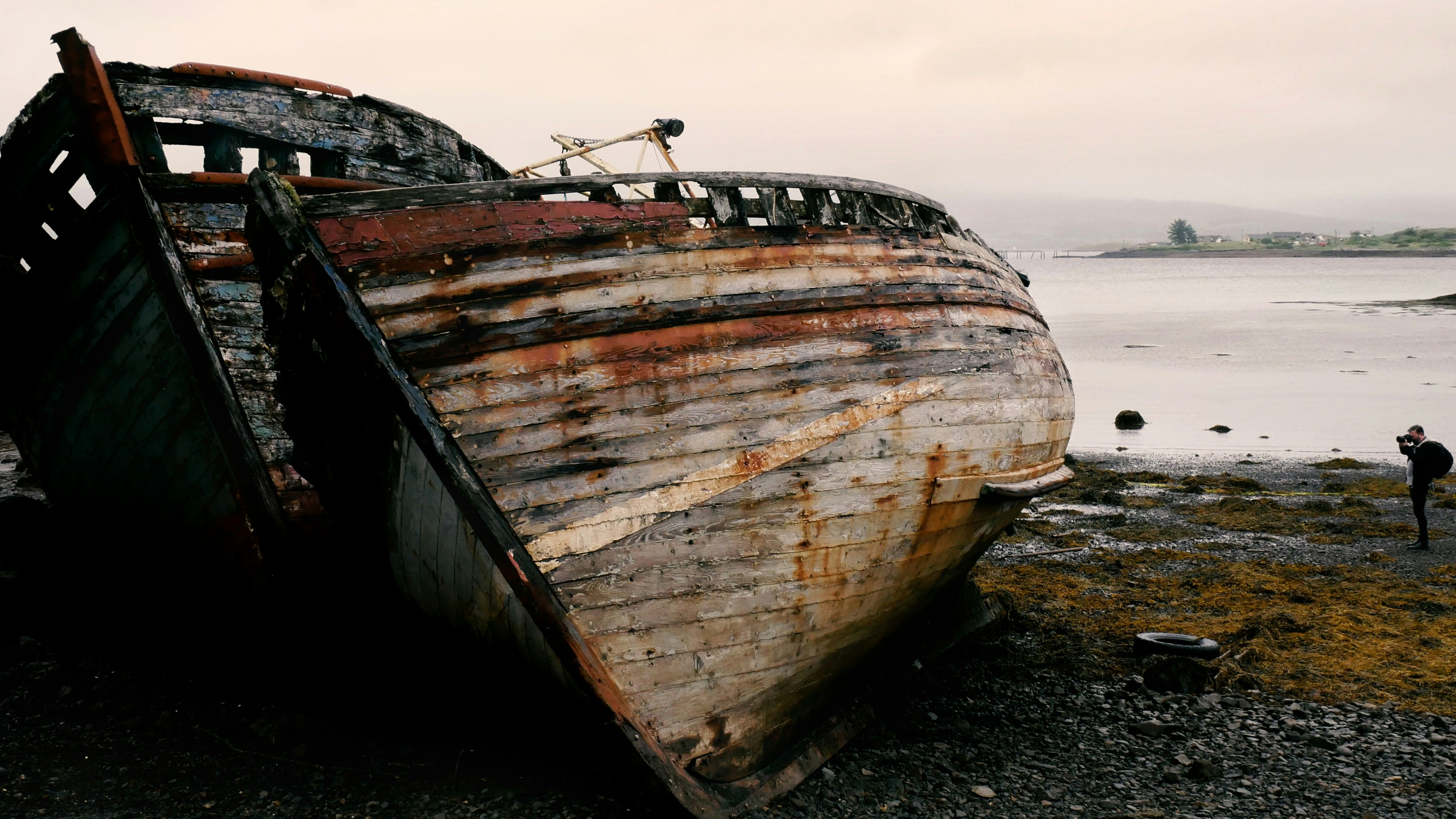 brown and white boat on black sand during daytime